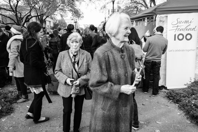 Two ladies walking through a Finnish tourism festival in Dupont Circle.