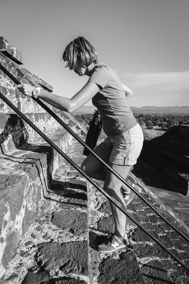 A woman climbing up the steps of the Pyramid of the Moon in Teotihuacán.