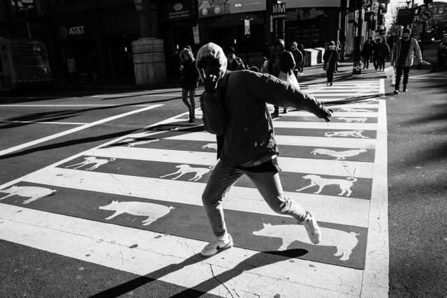 A dude making a gesture while crossing H street in Chinatown.