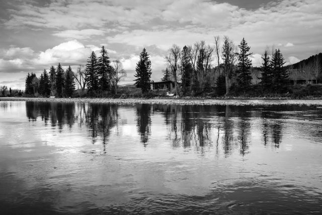 A line of trees and a cabin seen across the Snake River in Grand Teton National Park.