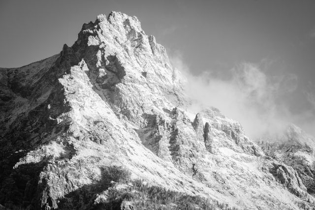 Teewinot Mountain, covered in the first big snowfall of the fall, at sunrise, with a cloud clinging to its side.