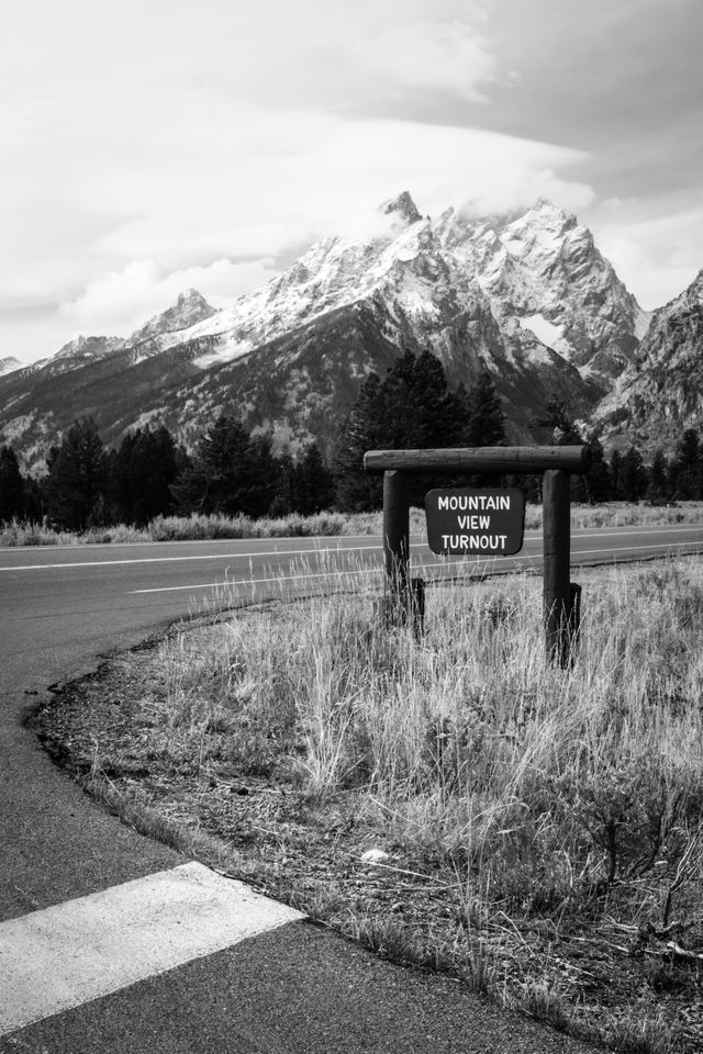 A sign at the Mountain View Turnout, with Teewinot Mountain and Mount Owen in the background.