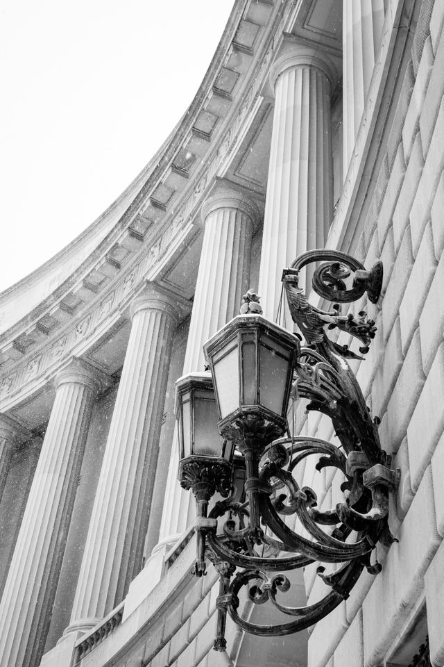 A very ornamented lamp under a group of columns at the Ronald Reagan Building & International Trade Center.