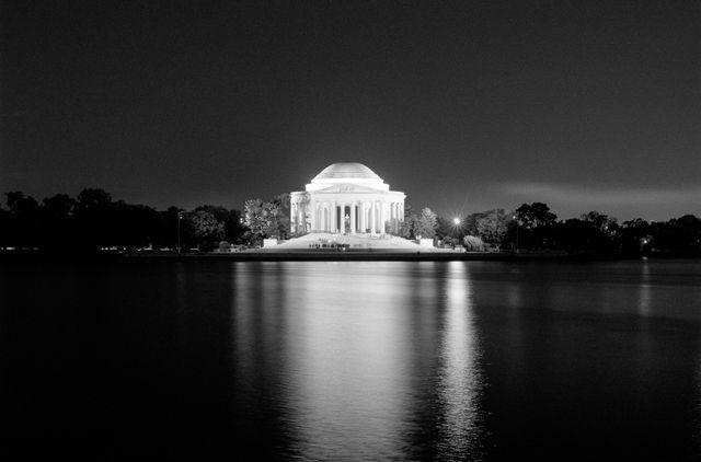 The Jefferson Memorial reflected off the Tidal Basin at night.