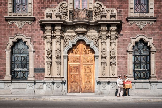 A couple of "organilleros" or organ grinders in front of the Anfiteatro Bolívar, an old building in the historic center of Mexico City.