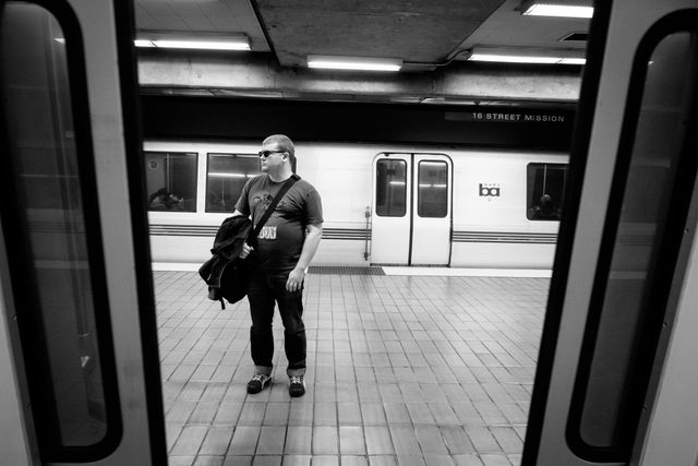 A man waiting on the platform at the 16th Street BART station.