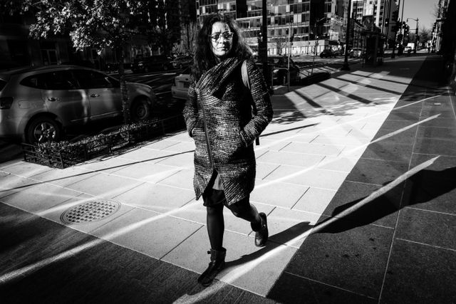 A pedestrian walking on a sunlit sidewalk near CityCenterDC.