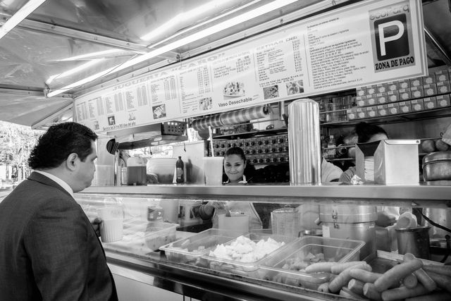 A man shopping at a juice cart in Mexico City.