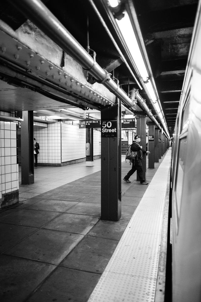 A person running to get on a train at the 50th Street station.