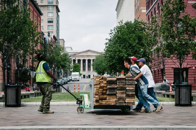 Workers pushing a cart of timber at the United States Navy Memorial in Washington, DC.