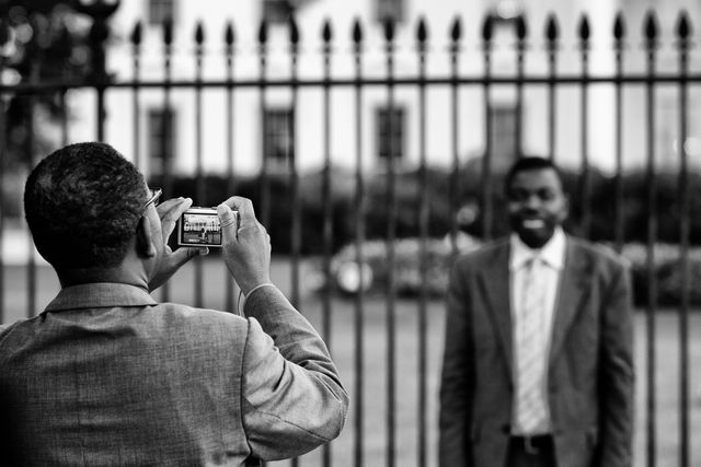 Tourists posing in front of the White House