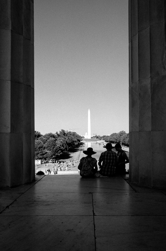 Tourists looking at the Reflecting Pool and the Washington Monument from the Lincoln Memorial.