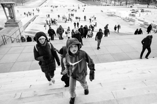 Two kids and a woman climbing the stairs of the Lincoln Memorial.