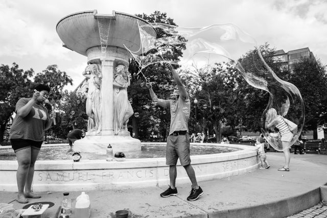 A man making a giant soap bubble in Dupont Circle, Washington, DC.