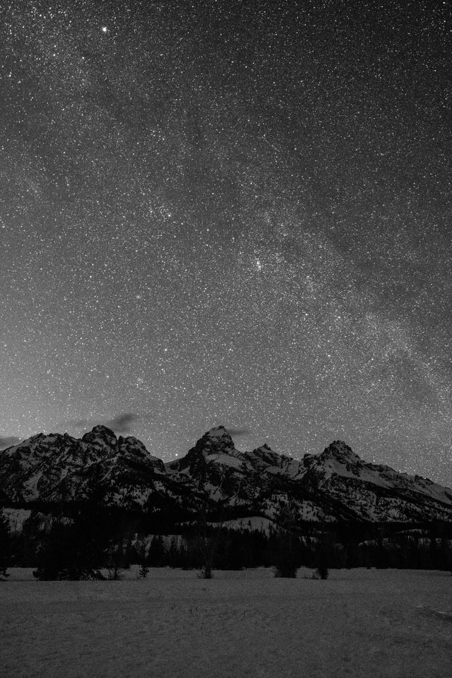 The starry night sky seen above Grand Teton, with a faint hint of the Milky Way.