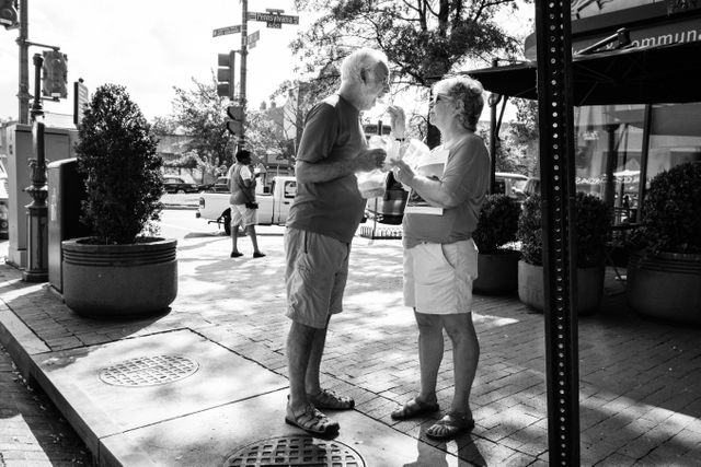 A woman feeding ice cream to a man in Eastern Market, Washington, DC.