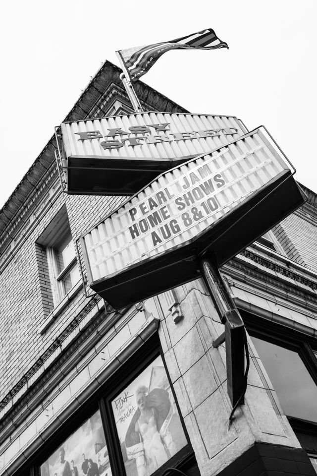 The sign in front of Easy Street Records with the dates of the Pearl Jam Home Shows, with a Pearl Jam flag flying above.