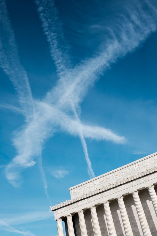 The Lincoln Memorial in front of a bright blue sky in Washington, DC.