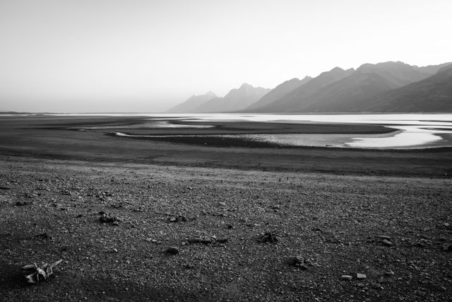 The dry lake bed of Jackson Lake after being drawn down, seen from the Jackson Lake overlook on a hazy afternoon.