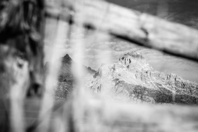 Teewinot Mountain and Mount Owen, seen through an out-of-focus wooden fence.