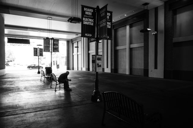 A man sitting on a bench at the electric shuttle station in Chattanooga.