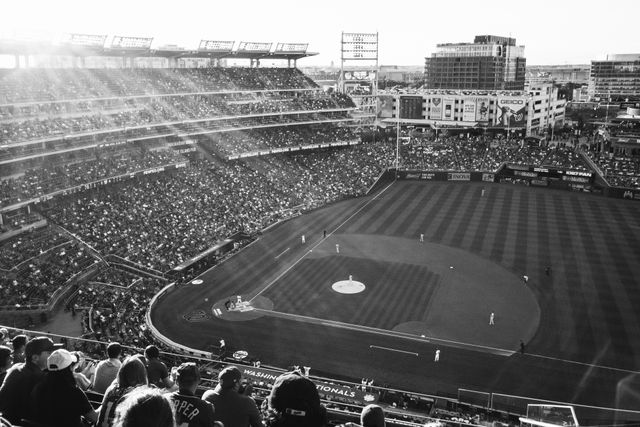 A Nationals vs. Orioles baseball game at Nationals Park at sunset, seen from the stands on the first base side.