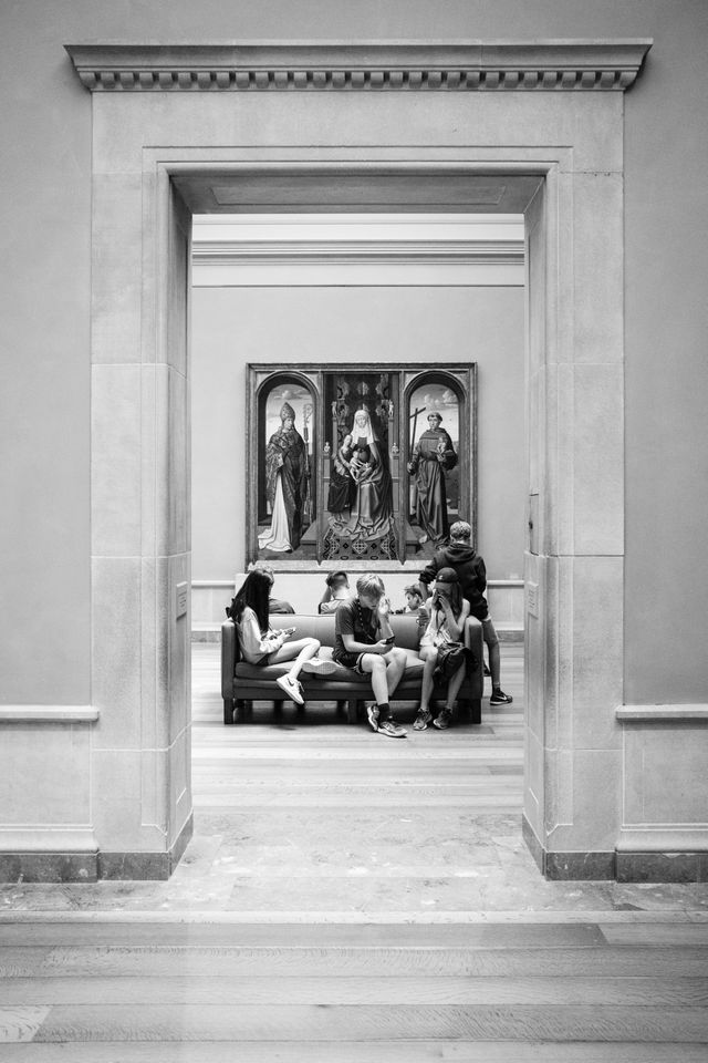 A group of kids sitting on a couch at the National Gallery of Art.