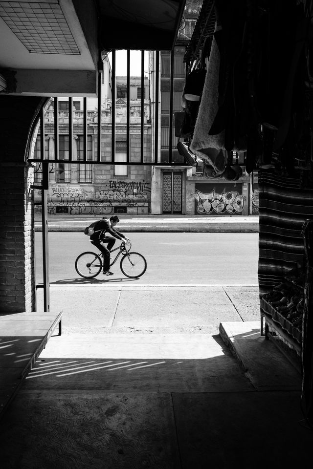 A man riding a bike past an entrance to La Ciudadela in Mexico City.