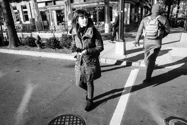 A woman crossing the street near 14th Street NW/