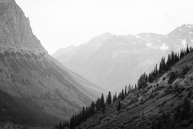 Mount Oberlin and the Going-to-the-Sun Road, with mountains in the background, on a hazy day.