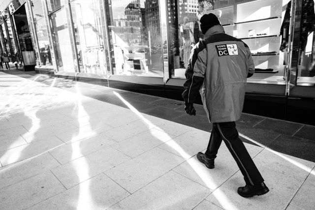 A Downtown Washington city employee walking on the sidewalk near CityCenterDC.