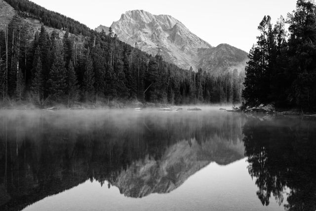 Mist floating over the surface of String Lake at dawn. Mount Moran can be seen in the background.