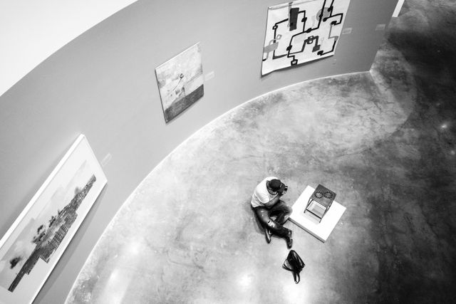 A person photographing a work of art at the Katzen Arts Center.