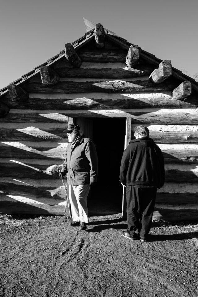 Visitors observing a soldier's cabin at Muhlenberg's Brigade in Valley Forge.