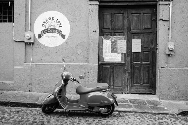 A scooter parked in front of a shut down cantina in San Ángel.