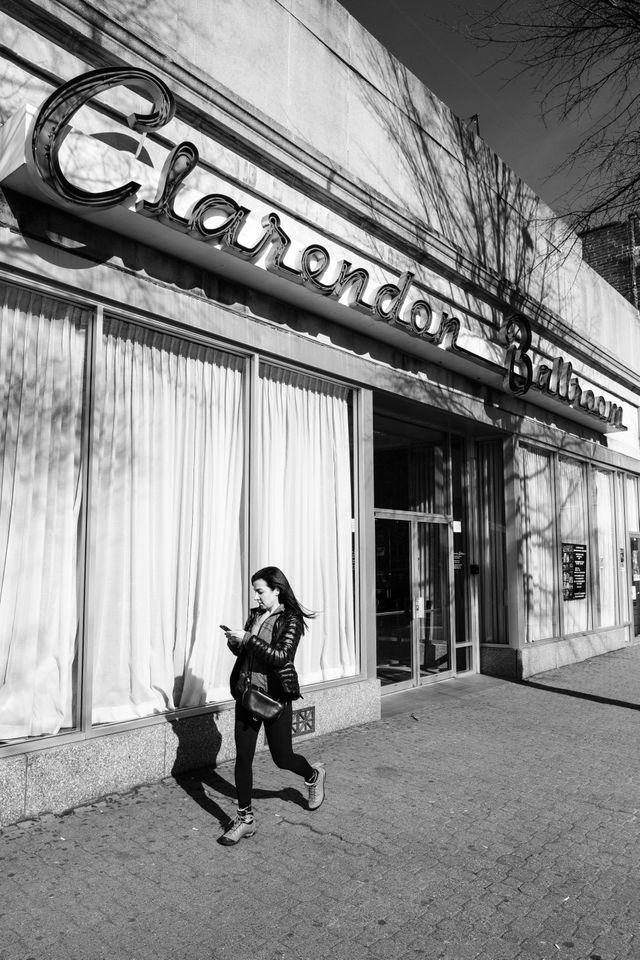 A woman walking in front of the Clarendon Ballroom in Arlington, Virginia.