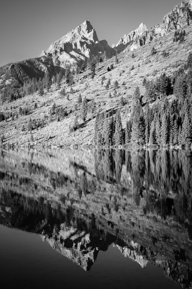 Teewinot Mountain and Grand Teton, reflected off the surface of String Lake.