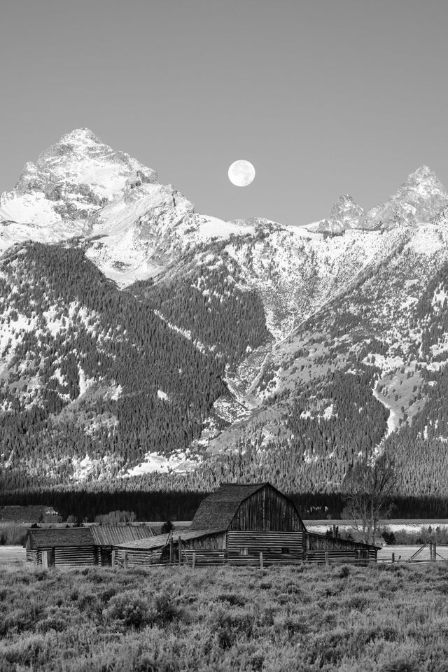 The John Moulton barn at Mormon Row. In the background, the Moon setting behing the Tetons.