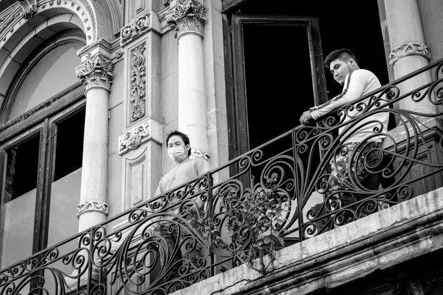 Two construction workers on a balcony in Mexico City.