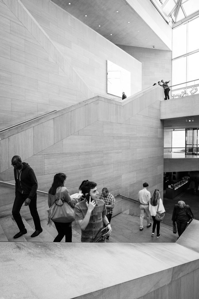 People walking up the stairs at the East Building of the National Gallery of Art in DC.