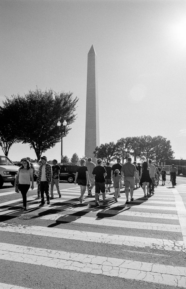 Tourists crossing the street towards the Washington Monument.