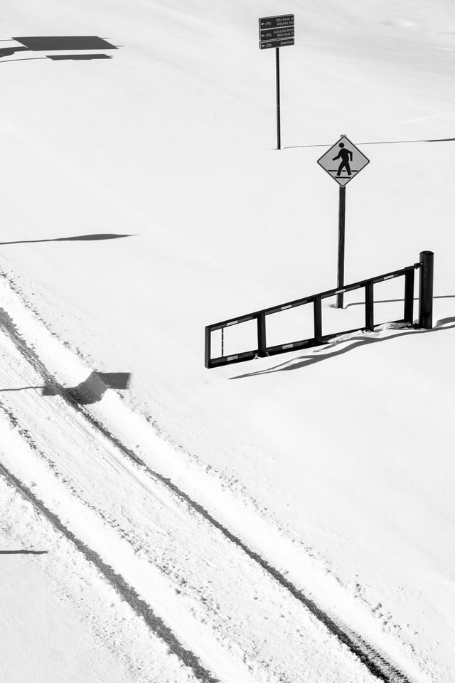 Tire tracks in the snow next to a gate in Anacostia Park.