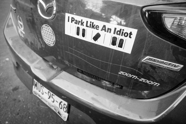 A keyed car with an "I Park Like An Idiot" sticker.