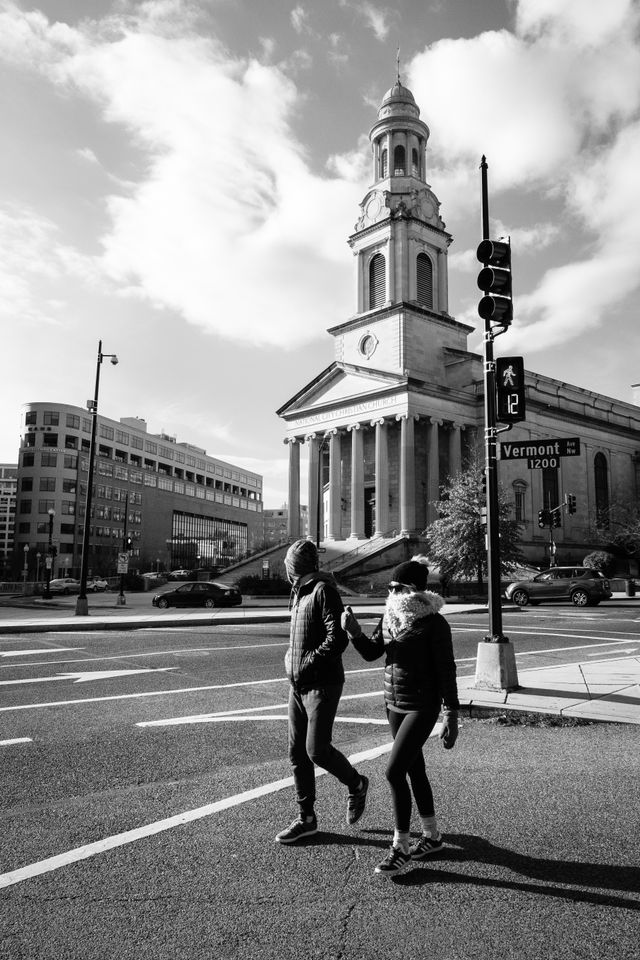 Two pedestrians walking in front of the National City Christian Church in Thomas Circle.