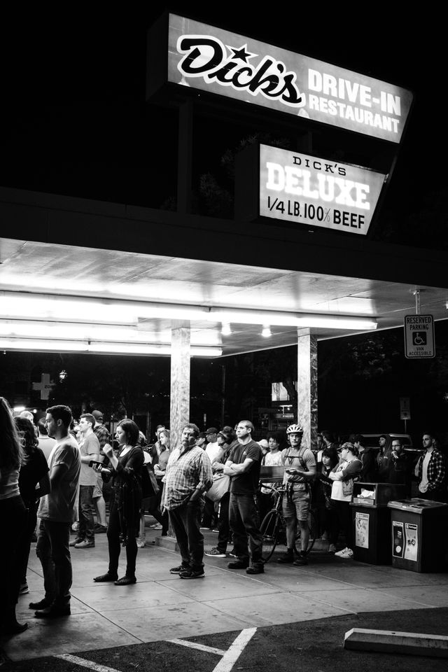 A line of people waiting to order food at night at Dick's Drive-In Restaurant in Capitol Hill, Seattle.