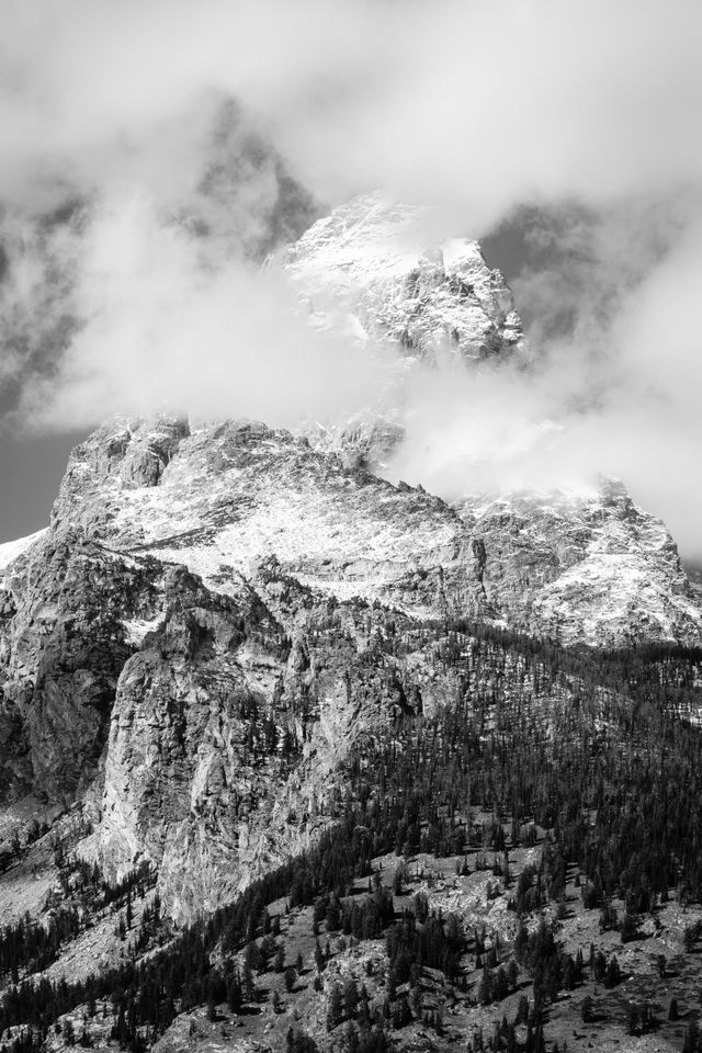 Grand Teton and Disappointment Peak. The summit of the Grand is covered in snow, and partially hidden by clouds.