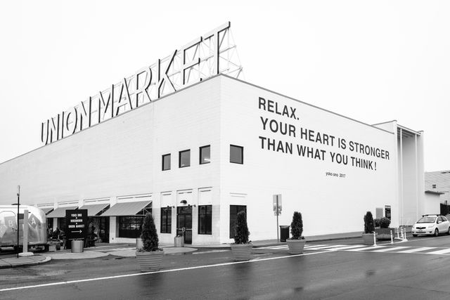 The facade of Union Market, featuring a mural with a quote from Yoko Ono that reads "Relax, your heart is stronger than what you think".