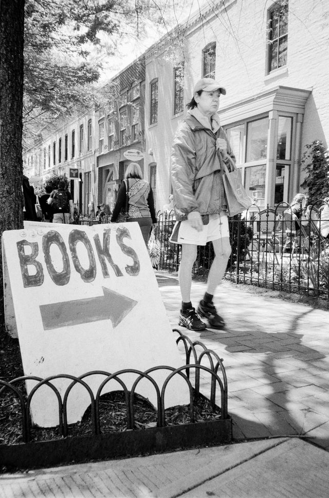 A person walking in front of a "books" sign in Eastern Market.