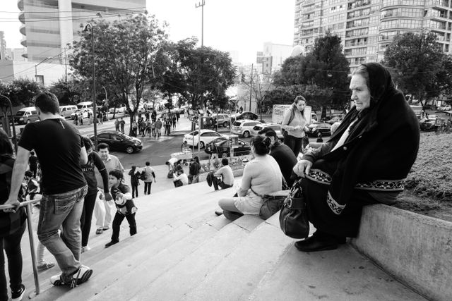 A woman sitting on the steps outside the Museo Soumaya.