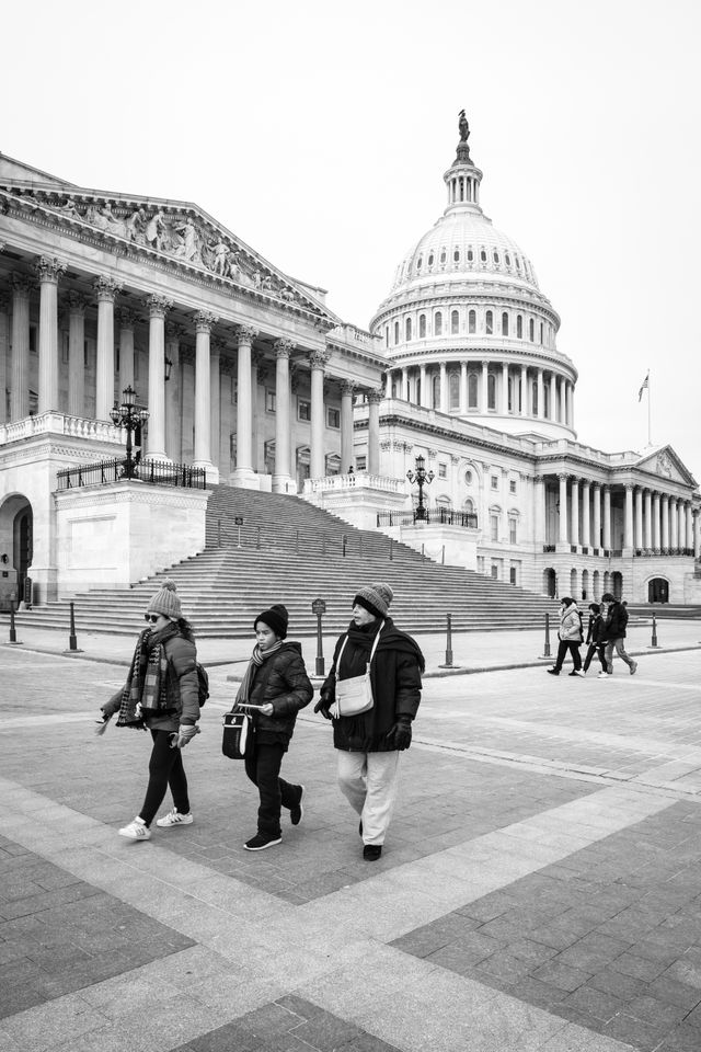 People walking in front of the United States Capitol.